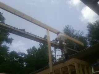 Carpenter setting a ridge beam over a new addition frame — Ice Dam Removal by Roofing Brothers in Shandaken