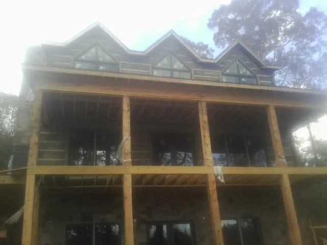 Dormers and porch framing on a large log home under construction — Roof Coating work by our crew in Shandaken