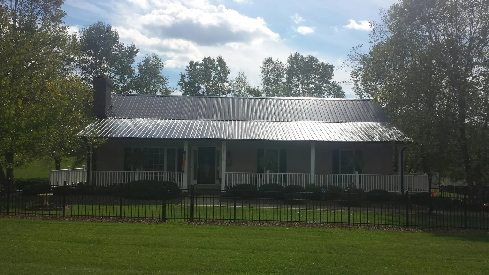 Gray metal roof on a brick ranch with a full width front porch — Gutter Guard Installation work by our crew in Shandaken