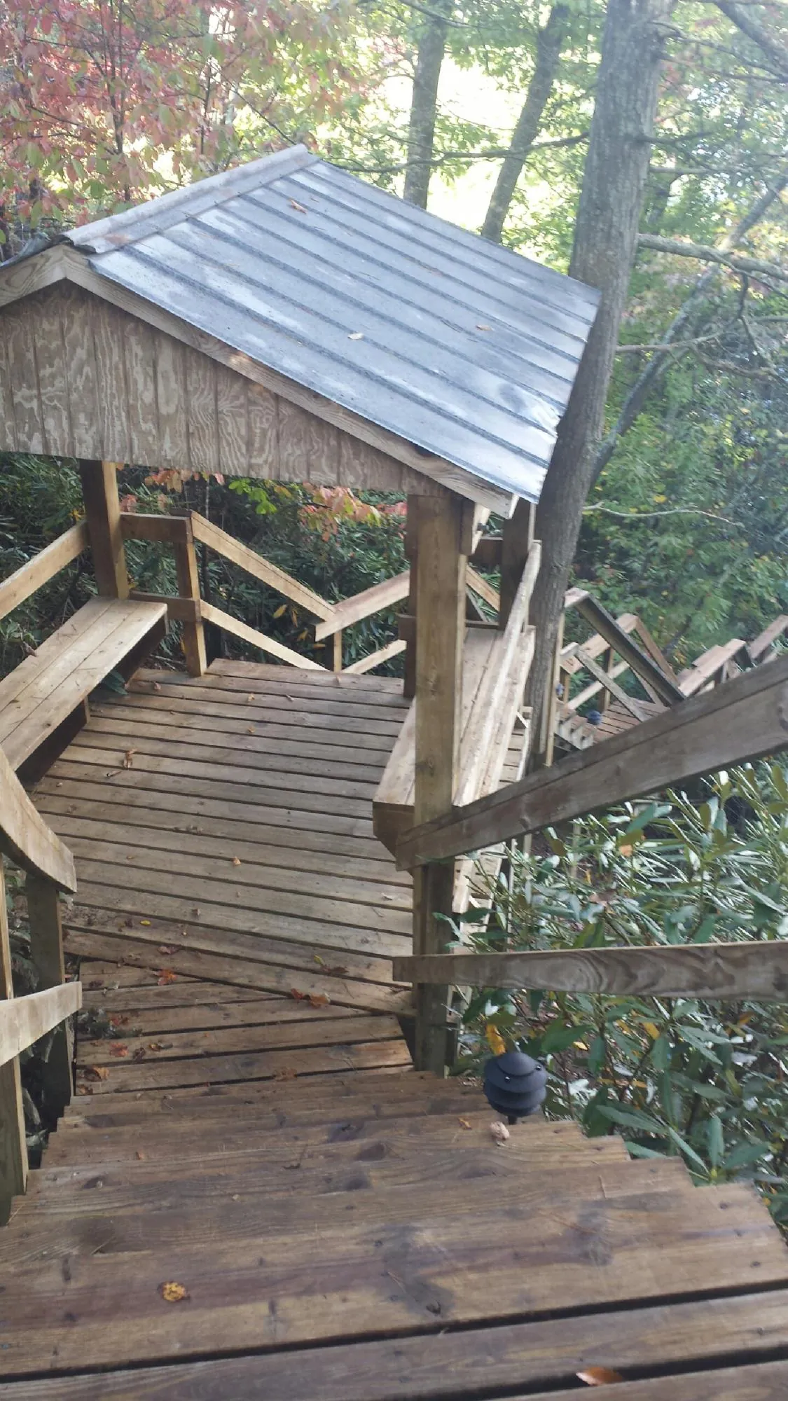 Metal roofed shelter over wooden steps on a wooded walkway — Skylight Repair & Installation work by our crew in Shandaken